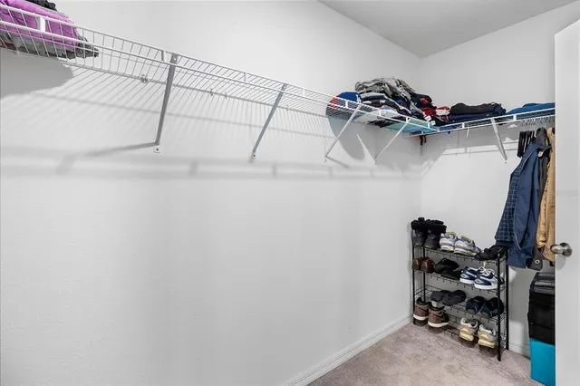 a view of walk in closet with clothes and shoes
