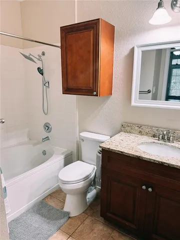 a bathroom with a granite countertop toilet sink and mirror