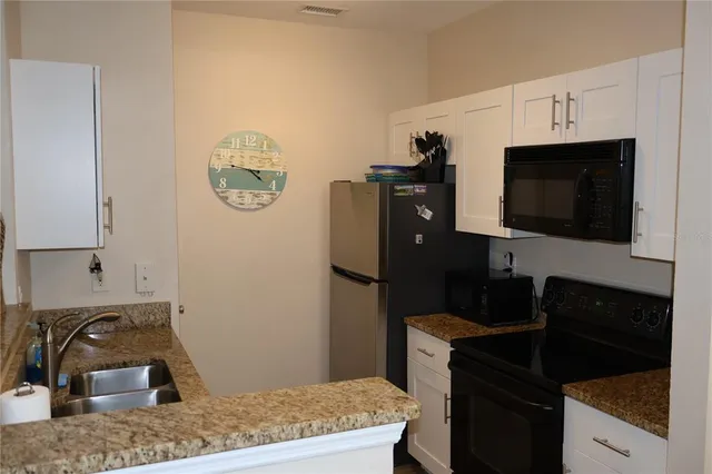 a kitchen with a sink a stove top oven and refrigerator