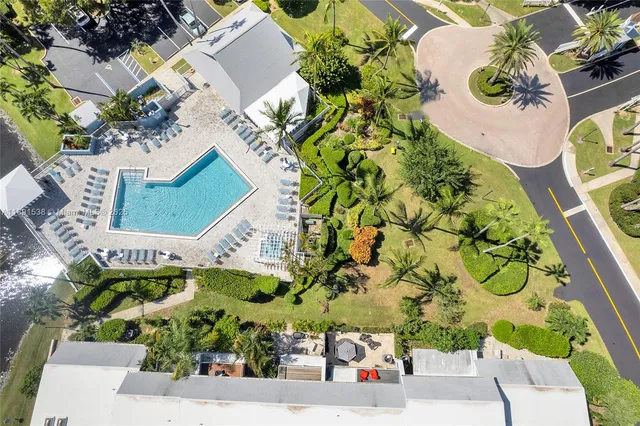 an aerial view of a house with a yard and a large tree