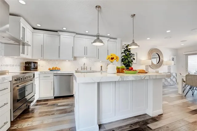a kitchen with white cabinets and stainless steel appliances