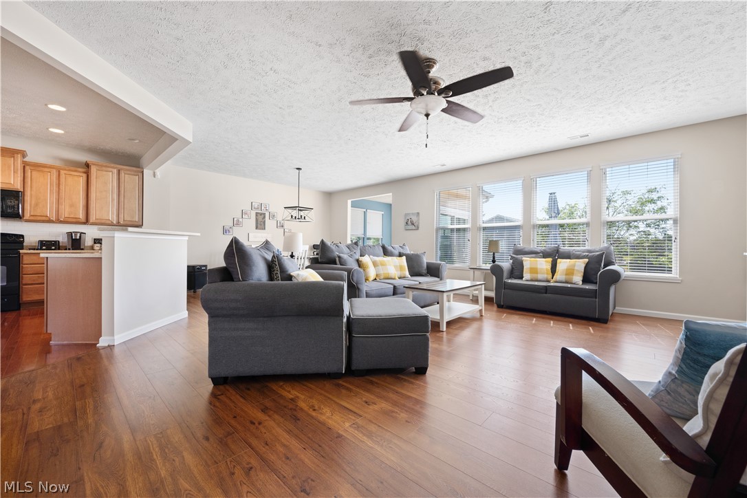 9188 Prairie Moon North Ridgeville, OH 44039 - Photo 9 of 40 Living room featuring a textured ceiling, wood-type flooring, and ceiling fan