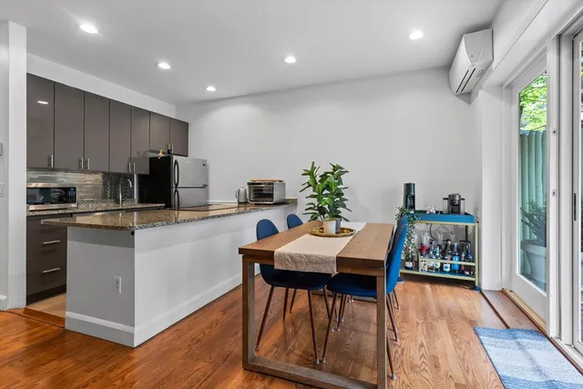 a kitchen with a table chairs refrigerator and microwave