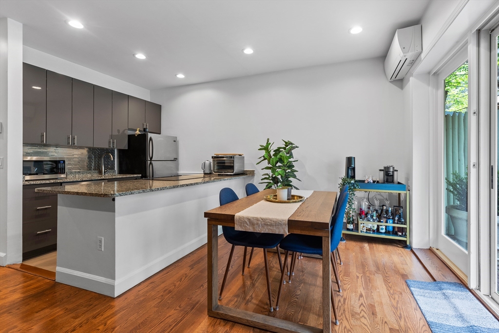 113 Chandler Street, Unit 1 Boston, MA 02116 - Photo 3 of 10 a kitchen with a table chairs refrigerator and microwave