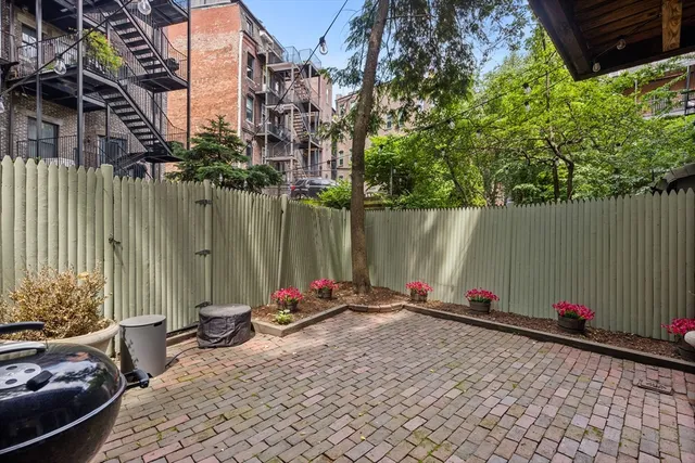 a view of a backyard with a table and chairs and potted plants