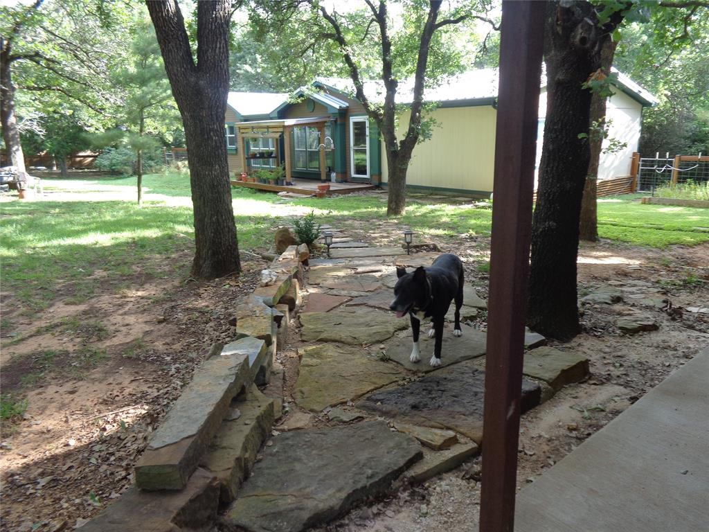 5525 Cedar Oaks Road Grandview, TX 76050 - Photo 29 of 40 Stone pathway leading to a residence with a metal roof