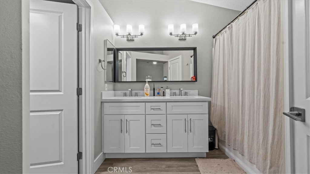 7550 Periwinkle Drive Fontana, CA 92336 - Photo 20 of 25 a bathroom with a double vanity sink and a mirror