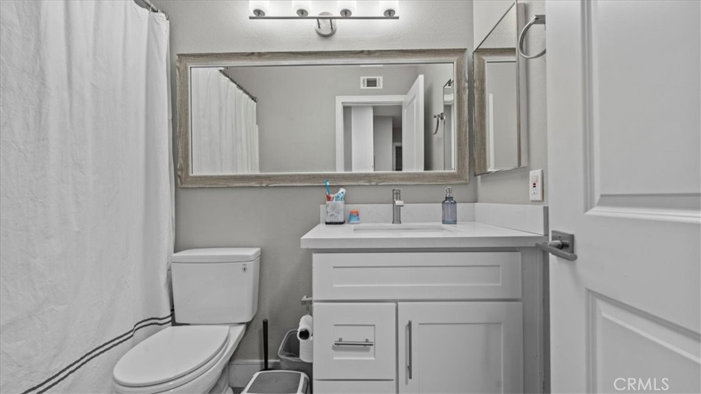 7550 Periwinkle Drive Fontana, CA 92336 - Photo 21 of 25 a bathroom with a sink vanity mirror and toilet