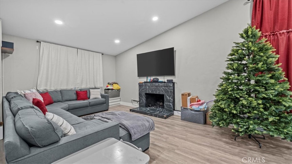 7550 Periwinkle Drive Fontana, CA 92336 - Photo 6 of 25 a living room with furniture a fireplace and a potted plant