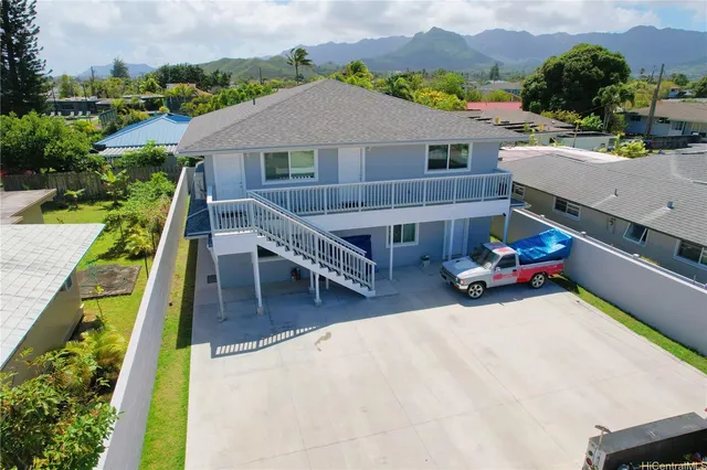 an aerial view of a house with swimming pool and large trees