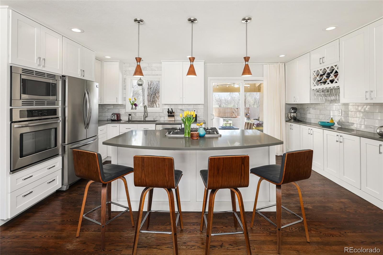 a kitchen with stainless steel appliances granite countertop a table chairs stove and wooden cabinets