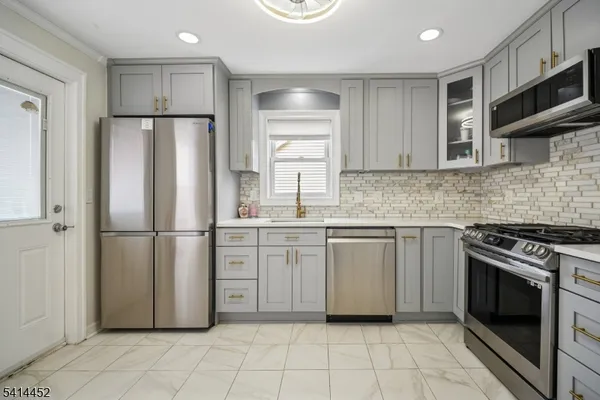 a kitchen with white cabinets stainless steel appliances and a sink