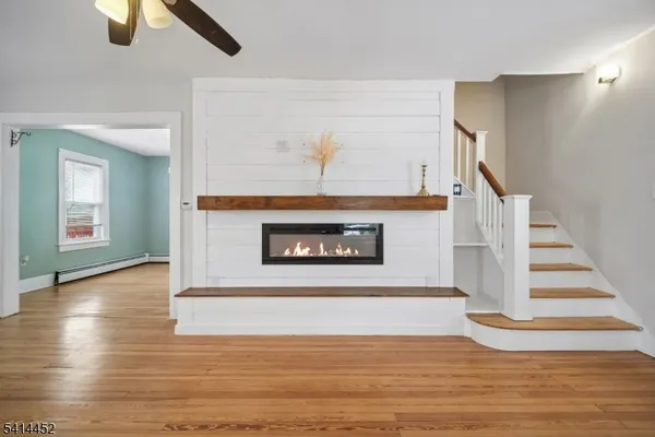 a view of staircase with a fireplace and wooden floor