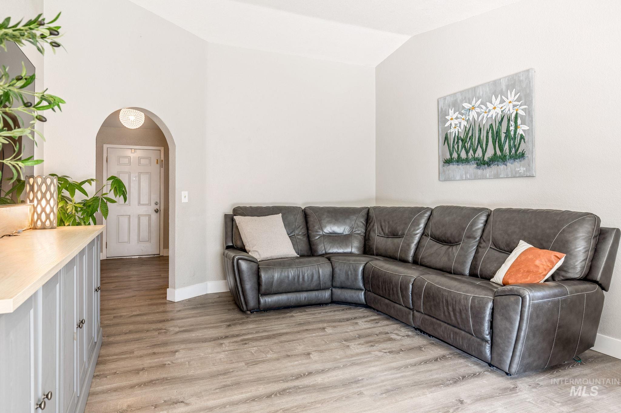 3209 Whitman Drive Boise, ID 83716 - Photo 11 of 45 Living area with arched walkways, vaulted ceiling, and light wood-type flooring