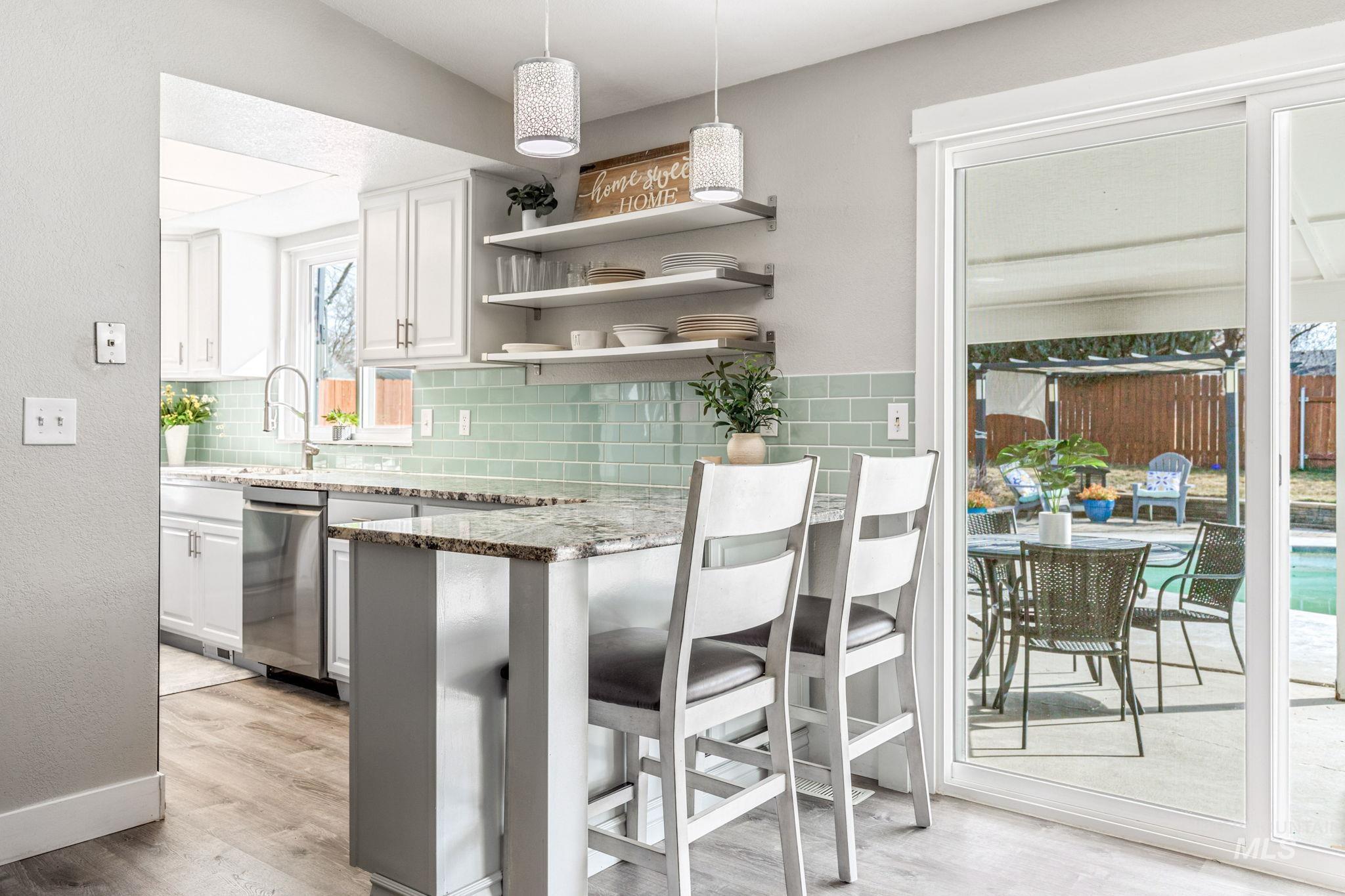 3209 Whitman Drive Boise, ID 83716 - Photo 14 of 45 Kitchen featuring white cabinets, open shelves, light wood-style flooring, decorative light fixtures, and stainless steel dishwasher