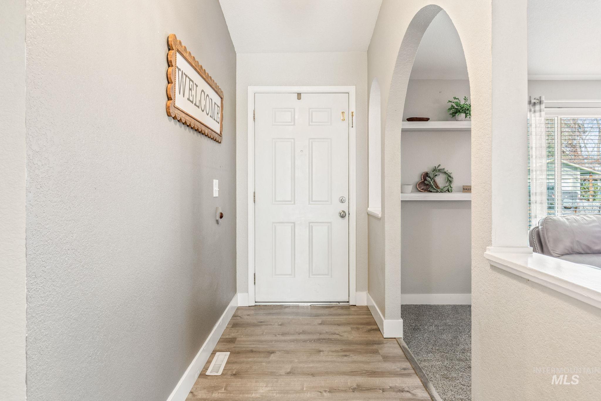 3209 Whitman Drive Boise, ID 83716 - Photo 4 of 45 Entryway featuring light wood finished floors, a textured wall, and arched walkways