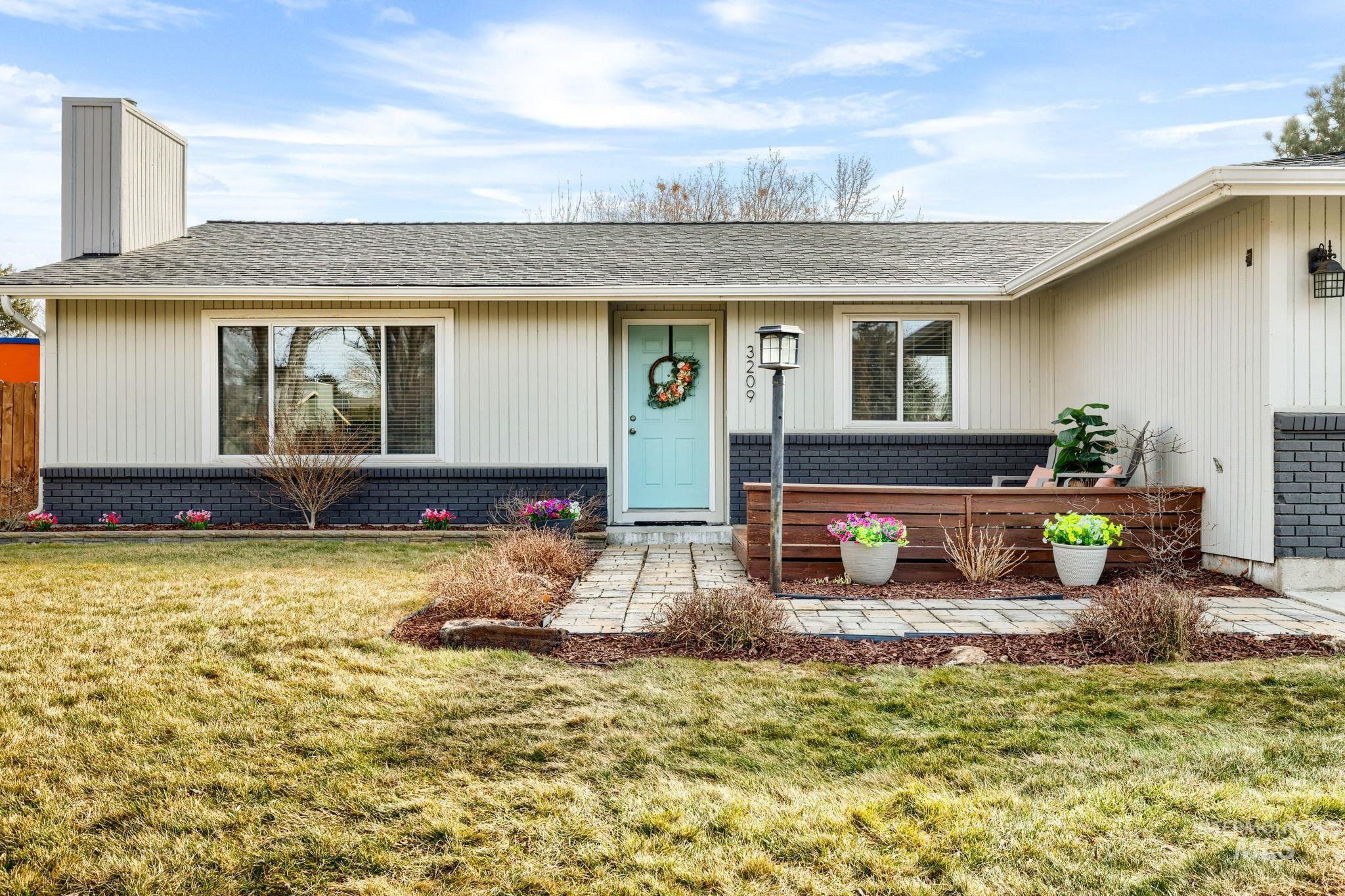 3209 Whitman Drive Boise, ID 83716 - Photo 45 of 45 Entrance to property featuring a shingled roof, a yard, brick siding, and a chimney