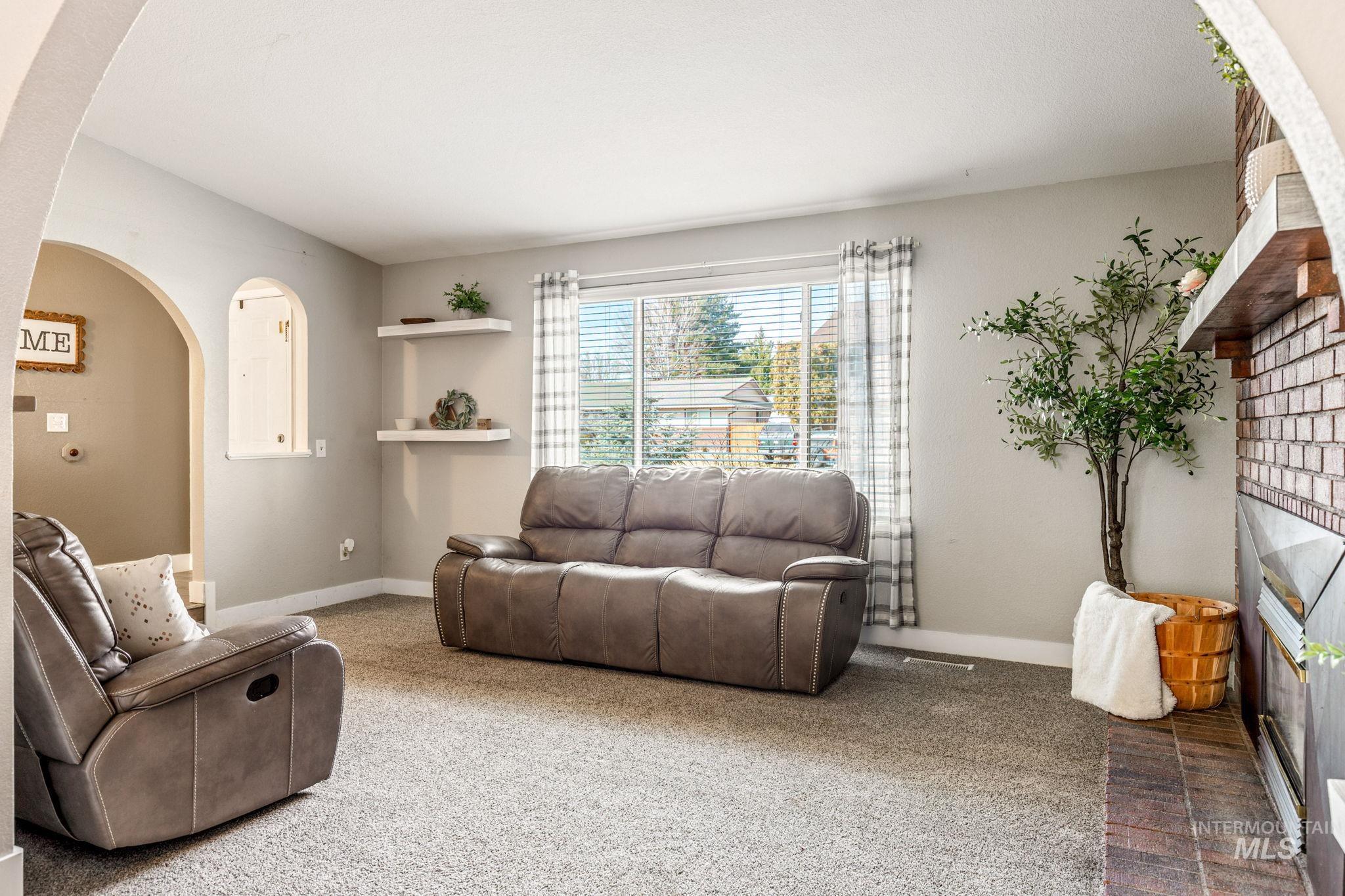 3209 Whitman Drive Boise, ID 83716 - Photo 6 of 45 Carpeted living room with arched walkways and baseboards