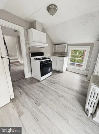 a kitchen with granite countertop a stove a sink and a refrigerator