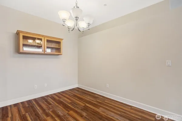 a view of a room with wooden floor and a chandelier