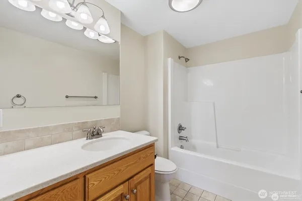 a bathroom with a granite countertop sink a toilet and shower