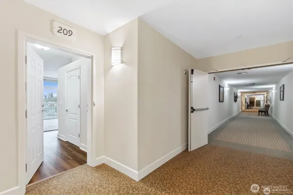 a view of a hallway with bathroom and wooden floor