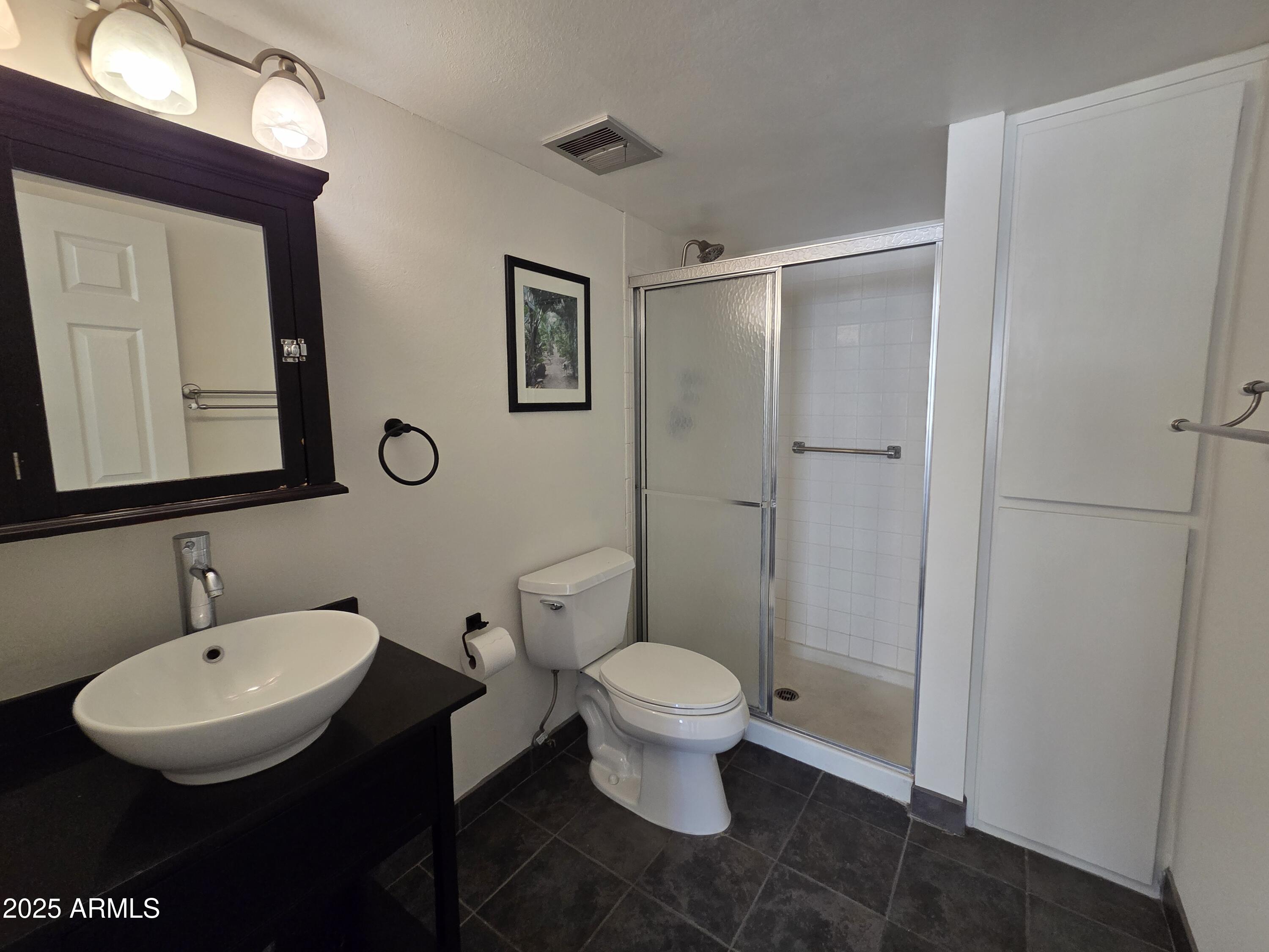 7920 East Camelback Road, Unit 408 Scottsdale, AZ 85251 - Photo 17 of 18 a bathroom with a toilet sink and mirror