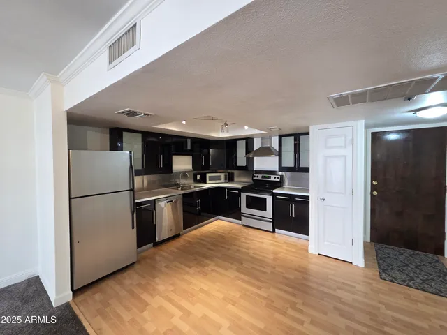 a kitchen with stainless steel appliances a refrigerator and a stove top oven
