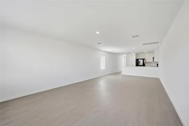 a view of a big room with wooden floor and windows