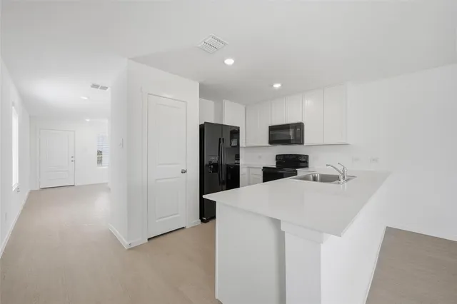 a kitchen with stainless steel appliances a refrigerator sink and microwave