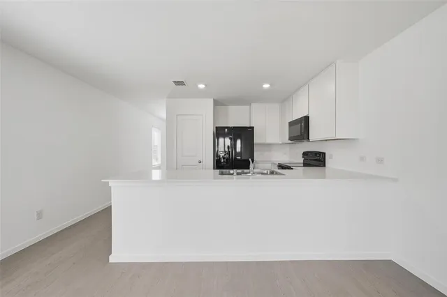 a view of kitchen with stainless steel appliances cabinets