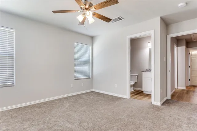 an empty room with closet and a chandelier fan