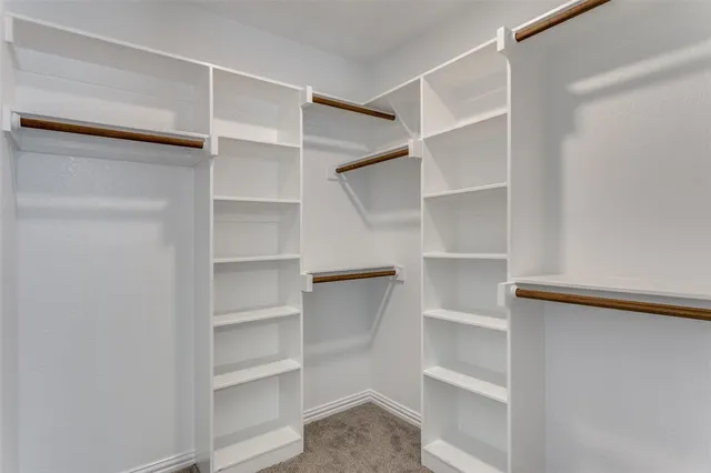 a view of walk in closet with empty racks