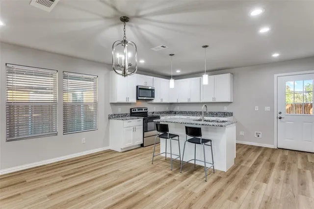 a kitchen with stainless steel appliances granite countertop a stove and cabinets