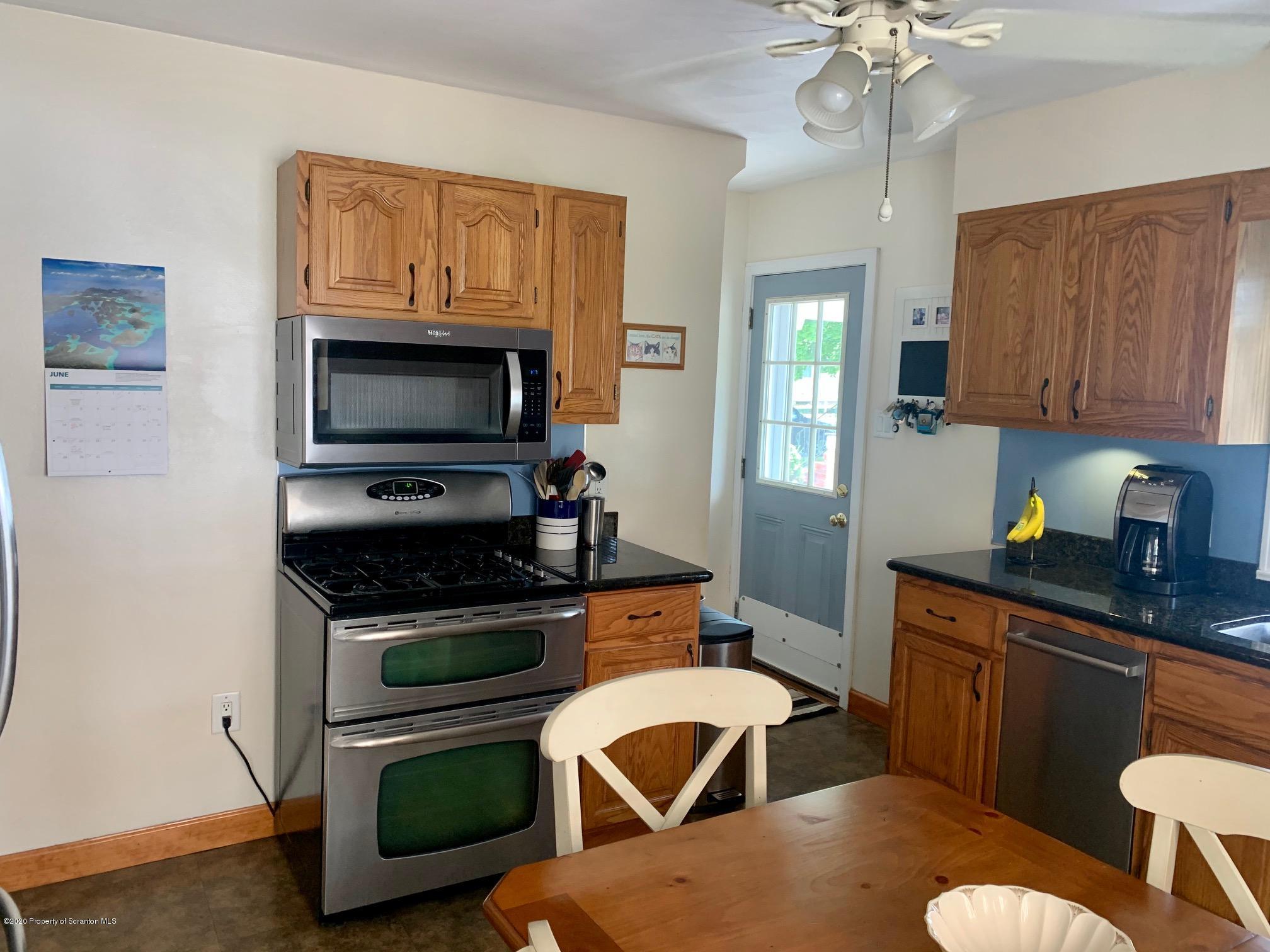 1094 Rutter Avenue Kingston, PA 18704 - Photo 11 of 35 a kitchen with stainless steel appliances a stove a sink dishwasher a microwave oven with a dining table and chairs