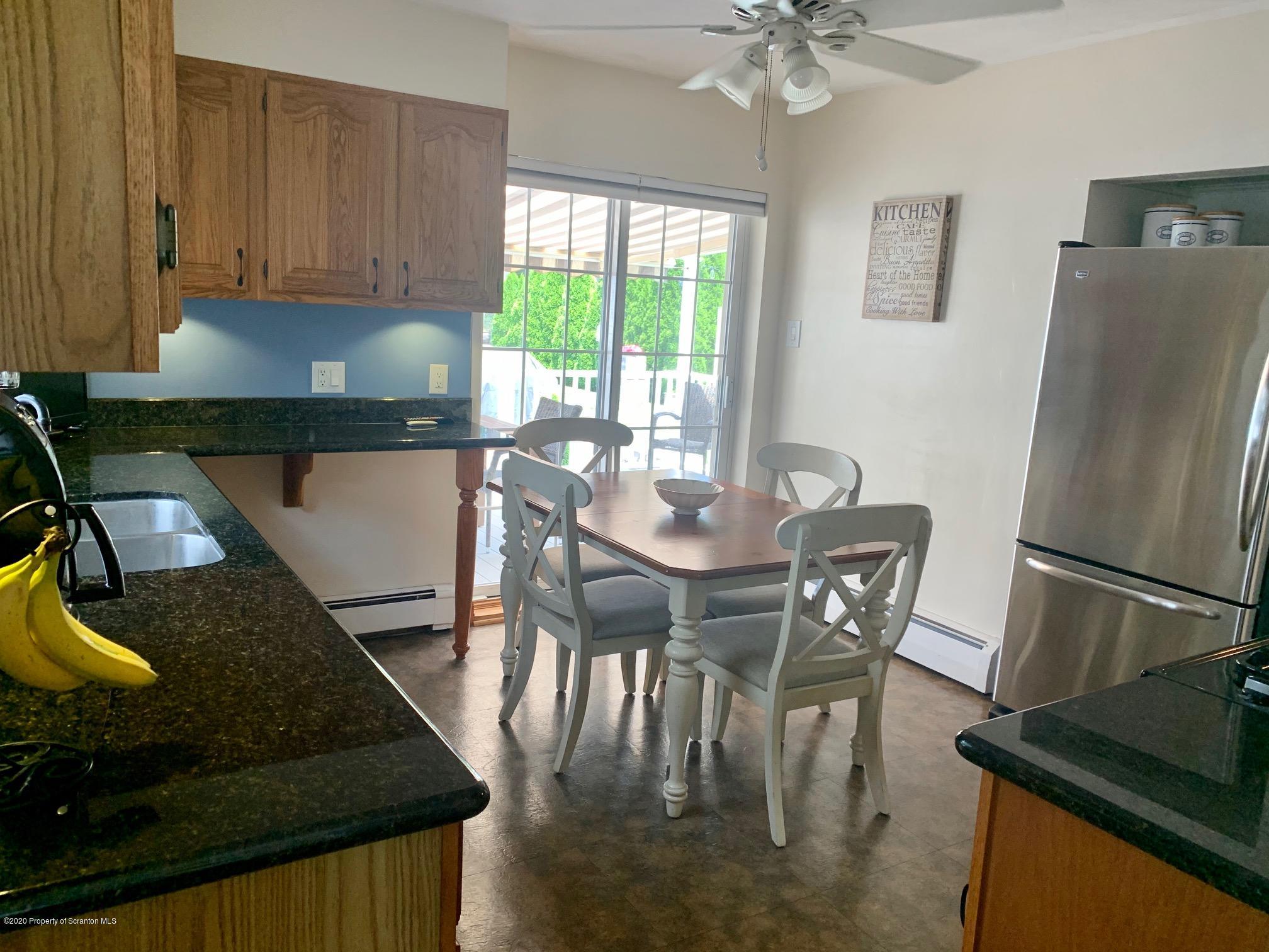 1094 Rutter Avenue Kingston, PA 18704 - Photo 12 of 35 a kitchen with a table chairs and a refrigerator