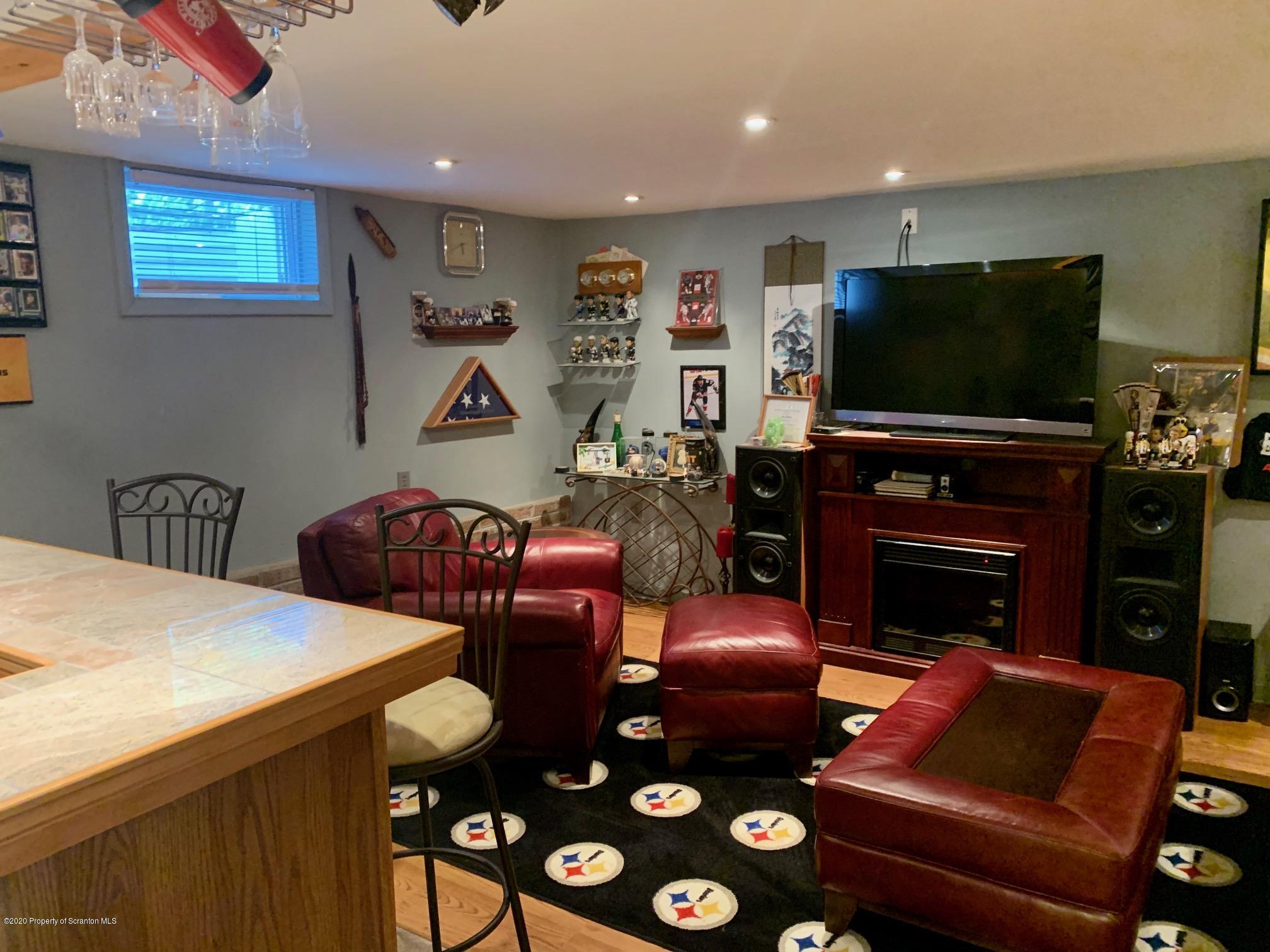 1094 Rutter Avenue Kingston, PA 18704 - Photo 26 of 35 a living room with furniture a flat screen tv and a fireplace