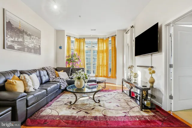 a living room with furniture a flat screen tv and a floor to ceiling window