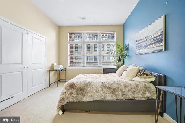 a bedroom with a bed and a large window