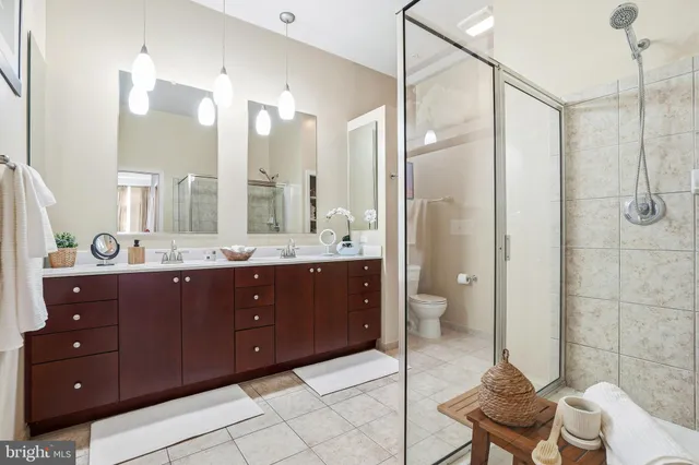 a spacious bathroom with a double vanity sink toilet and shower