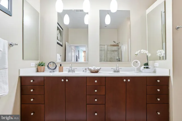 a bathroom with double vanity and a mirror