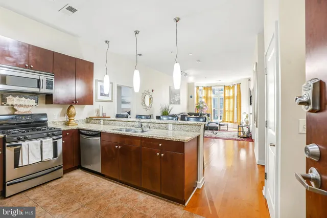 a large kitchen with stainless steel appliances kitchen island granite countertop a large counter top and stove
