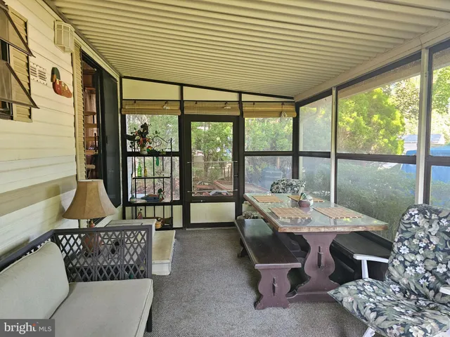 a dining room with furniture and large windows