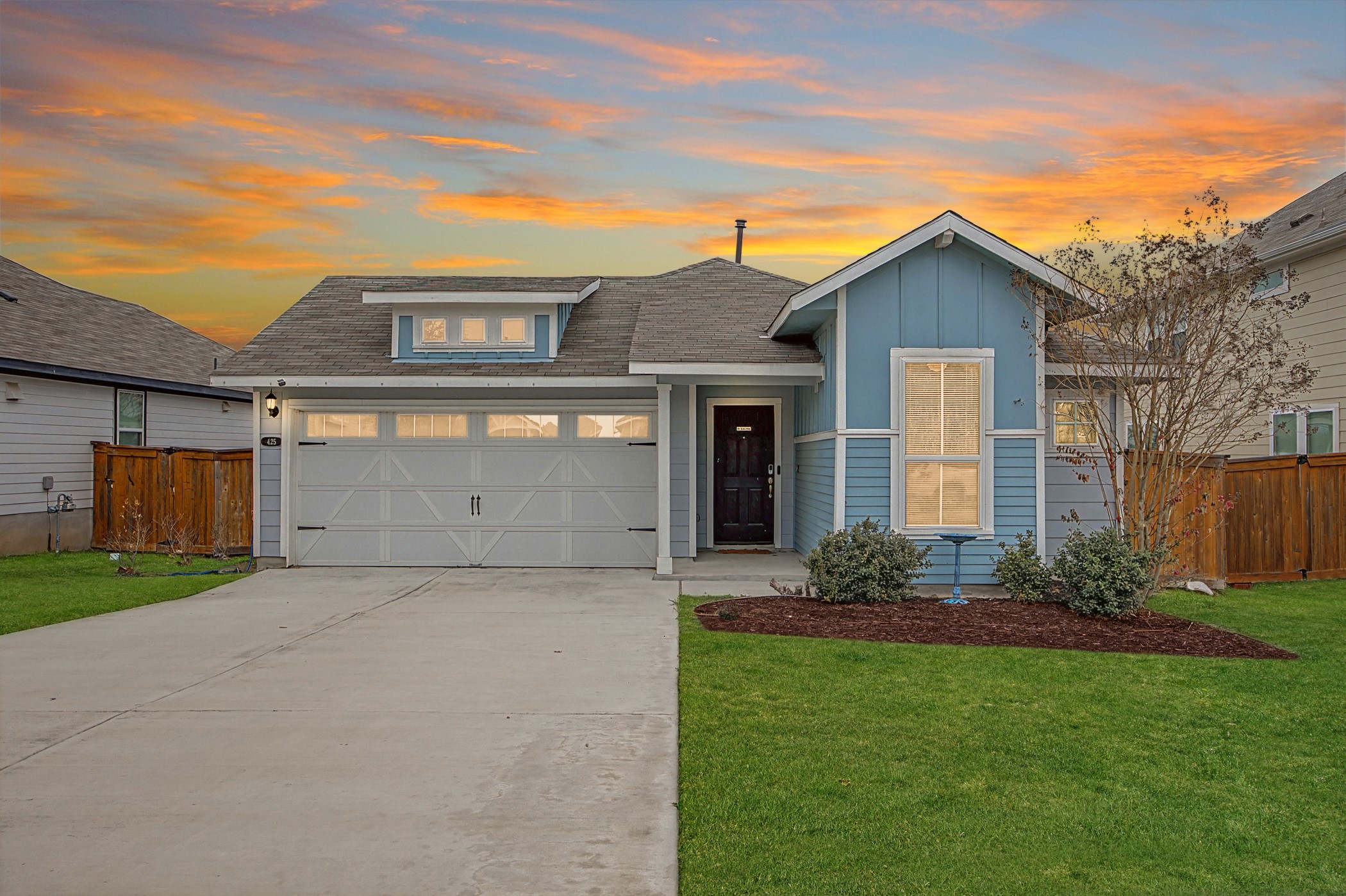 View of front of property featuring driveway, a garage, roof with shingles, and board and batten siding