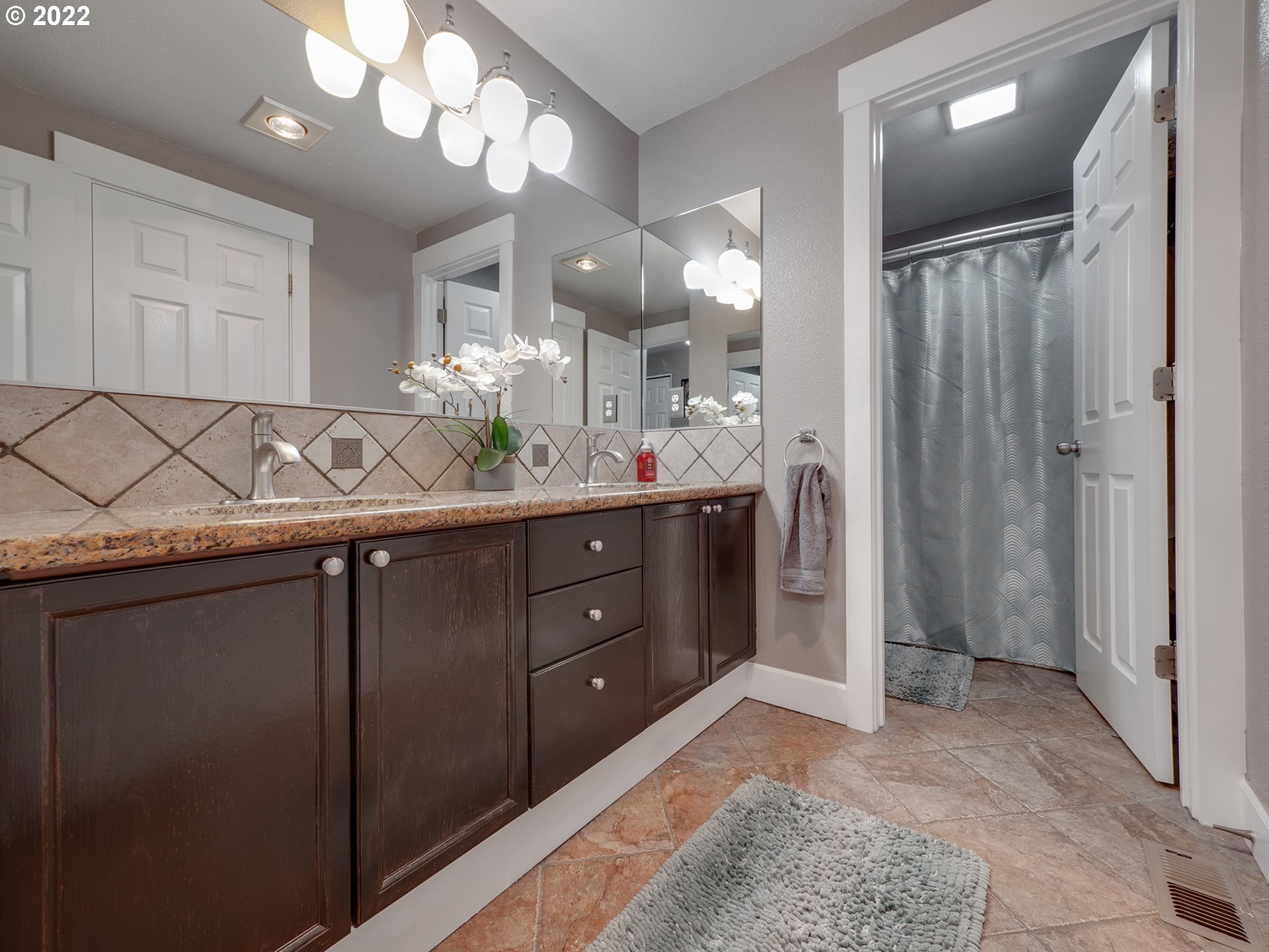 795 Brown Street Woodburn, OR 97071 - Photo 15 of 30 a bathroom with a granite countertop sink a mirror and a shower