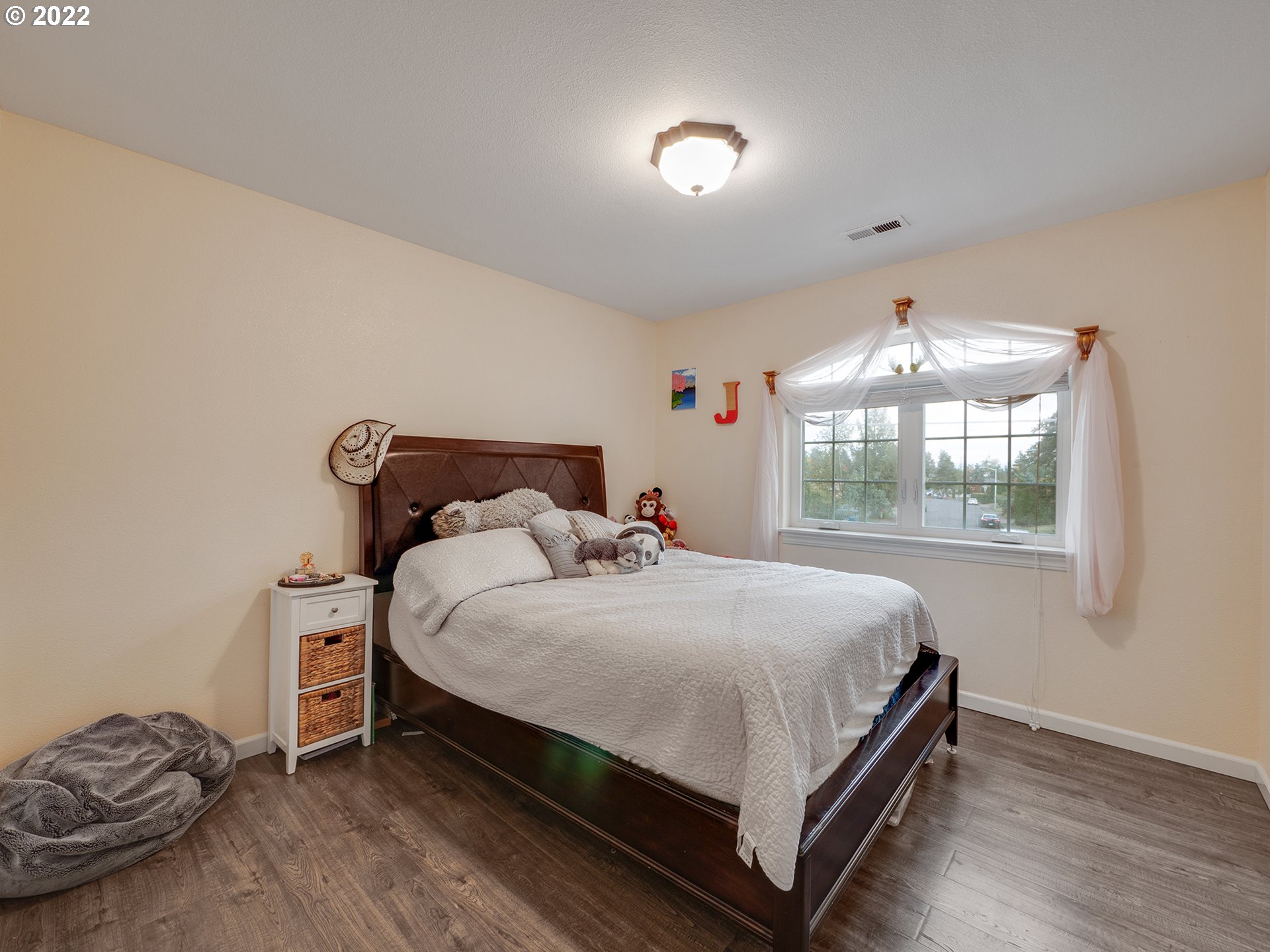 795 Brown Street Woodburn, OR 97071 - Photo 18 of 30 a bed sitting in a bedroom next to a window