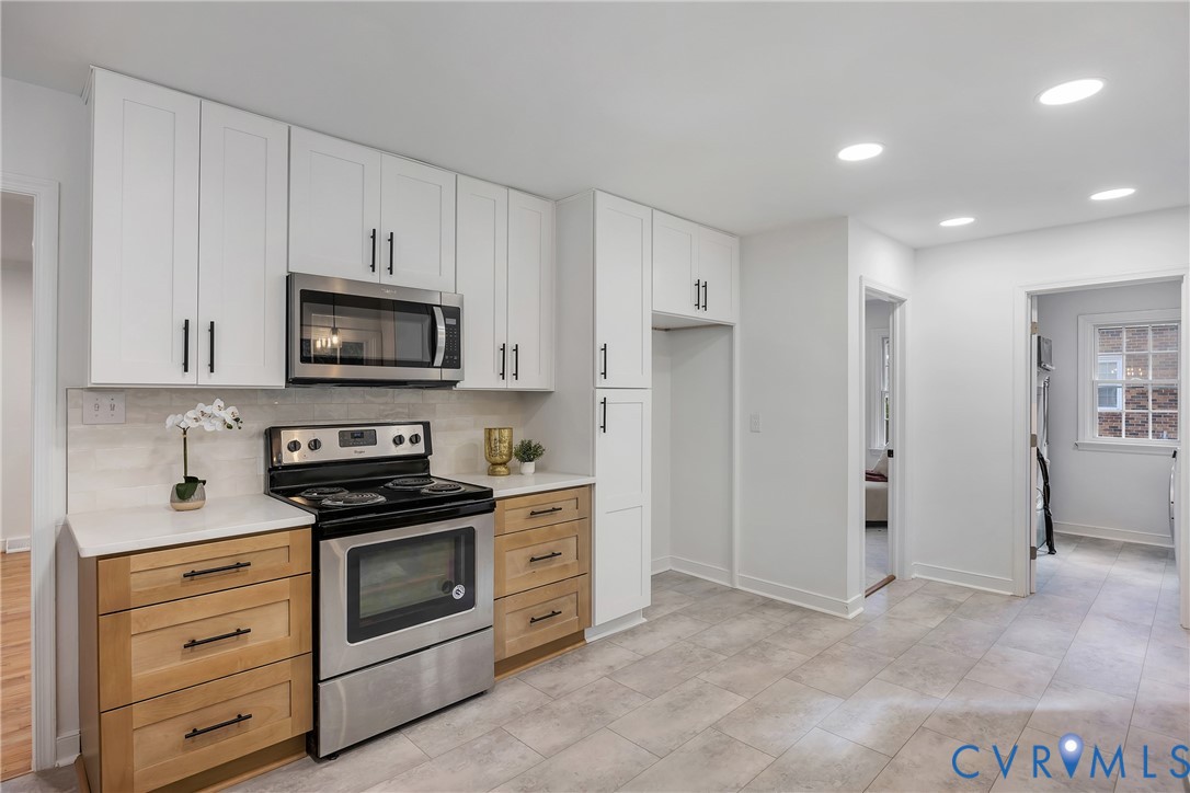 9099 Mossy Brook Road Mechanicsville, VA 23116 - Photo 14 of 29 a kitchen with white cabinets and stainless steel appliances