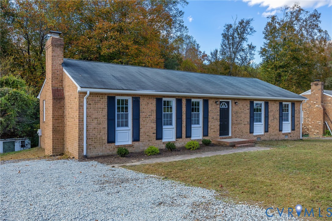 9099 Mossy Brook Road Mechanicsville, VA 23116 - Photo 3 of 29 a view of a brick house with a big yard and large trees