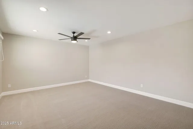 an empty room with a ceiling fan and a window