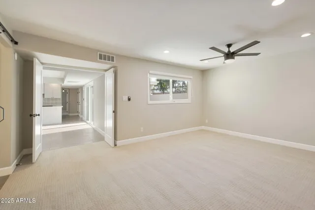 an empty room with fan and windows